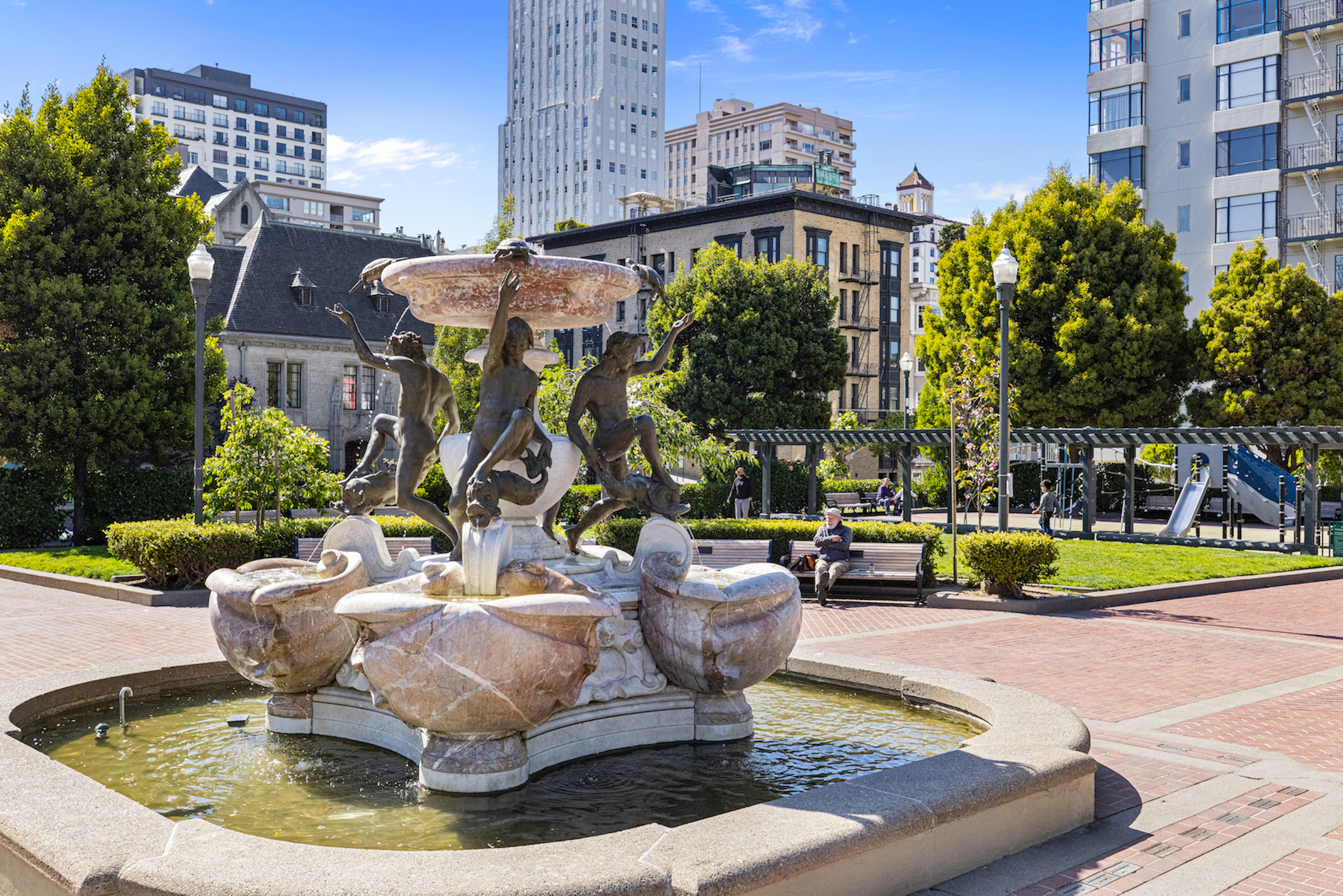 Huntington Park with decorative fountain, trees, and in background, Mark Hopkins brick building